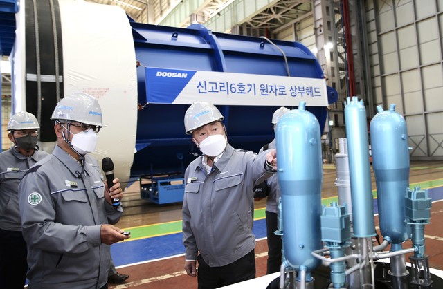 박정원 두산그룹 회장이 15일 경남 창원 두산에너빌리티 원자력 공장 내 원자로 헤드 앞에서 원전 모형을 보며 사업 현황을 점검하고 있다. (사진=DOOSAN)