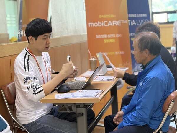 홍천군 주민이 웨어러블 심전도 모비케어에 대한 설명을 듣고 있다. [대웅제약 제공]