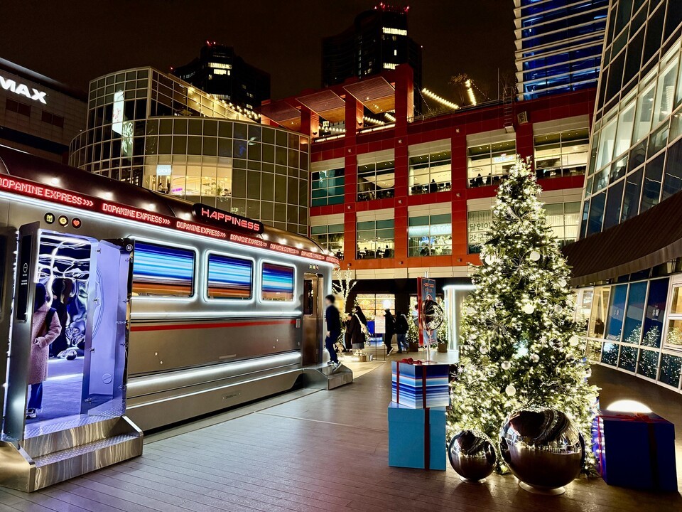 아이파크몰 4층 더 가든 해피니스 스테이션. 3층 연결통로는 기차역 플랫폼을 모티프로 한 ‘도파민 스테이션’으로 변신해 대형 미디어 파사드에 행복을 싣고 달리는 열차 영상이 상영된다. 4층 더 가든은 이국적인 부스와 화려한 조명으로 꾸며진 ‘해피니스 스테이션’으로, 오는 12월 28일까지 매주 새로운 테마의 릴레이 크리스마스 마켓이 열린다.